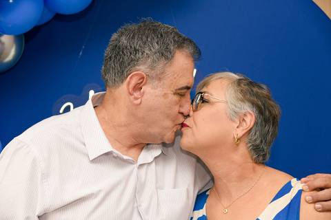 Fotografia do Aniversariante Na Mesa Do Bolo Beijando Sua Esposa no Tatuapé SP Feita por Priscila Felix Fotógrafa de Casamentos, Ensaios e Família'