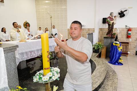 Fotografia Do Padrinho Do Batizado Acendendo A Vela Na Igreja São José em São Paulo, SP Feita por Priscila Felix Fotógrafa de Casamentos, Ensaios e Família'