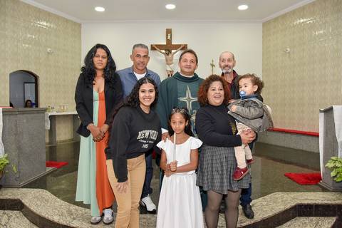 Fotografia Da Batizada Segurando A Vela Do Batismo Junto Com Os Pais, Padrinhos E O Padre No Altar Da Igreja São José em São Paulo, SP Feita por Priscila Felix Fotógrafa de Casamentos, Ensaios e Família'