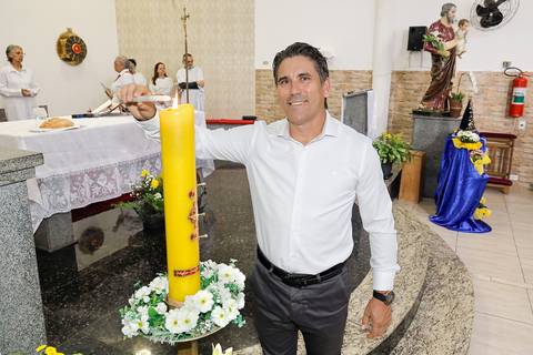 Fotografia Do Padrinho Do Batizado Ascendendo a Vela Na Igreja São José em São Paulo, SP Feita por Priscila Felix Fotógrafa de Casamentos, Ensaios e Família'