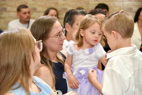 Fotografia Dos Irmãos Batizados Interagindo No Colo da Mãe Na Igreja São José em São Paulo, SP Feita por Priscila Felix Fotógrafa de Casamentos, Ensaios e Família'