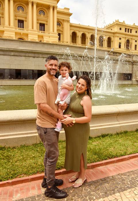 Foto do Casal Com a Filha No Colo, Ao Fundo O Museu do Ipiranga e Os Chafariz Ligados No Parque Da Independência em São Paulo - SP, Foto Feita Pela Priscila Felix Fotógrafa de Família, Casamento e Ensaios '