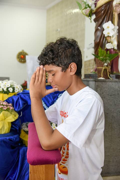 Fotografia Do Catequizado Ajoelhado No Oratório Com As Mãos Juntas Na Frente Do Rosto Na Igreja São José em São Paulo, SP Feita por Priscila Felix Fotógrafa de Casamentos, Ensaios e Família'