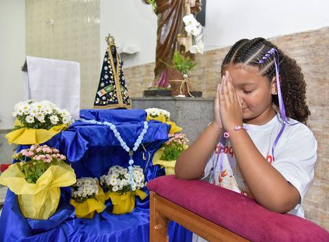 Fotografia Da Catequizada Ajoelhada No Oratório Com As Mãos Juntas Na Frente Do Rosto Na Igreja São José em São Paulo, SP Feita por Priscila Felix Fotógrafa de Casamentos, Ensaios e Família'