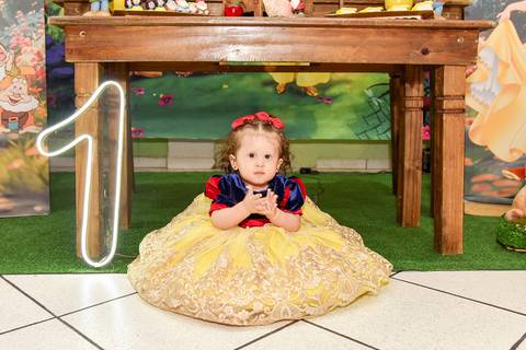 Foto da Aniversariante Vestida de Branca De Neve Roupa de Gala Sentada No Chão Em Frente à Mesa do Bolo Em São Paulo - SP, Foto Feita Pela Priscila Felix Fotógrafa de Família, Casamento e Ensaios '