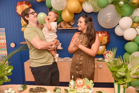 Foto do Aniversariante Mordendo A Bexiga No Colo Dos Pais Na Mesa do Bolo Em São Paulo - SP, Foto Feita Pela Priscila Felix Fotógrafa de Família, Casamento e Ensaios '