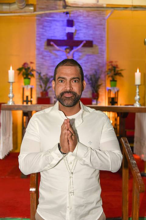 Fotografia Do Rafael De Mãos Unidas Em Oração Em Frente Ao Altar Na Paróquia São Judas Tadeu em São Paulo, SP Feita por Priscila Felix Fotógrafa de Casamentos, Ensaios e Família'