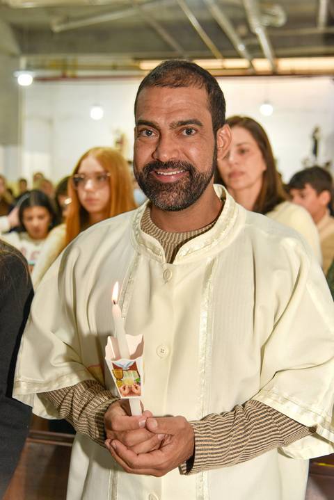 Fotografia Do Rafael Sorrindo Segurando A Vela Da 1ª Comunhão Na Paróquia São Judas Tadeu em São Paulo, SP Feita por Priscila Felix Fotógrafa de Casamentos, Ensaios e Família'