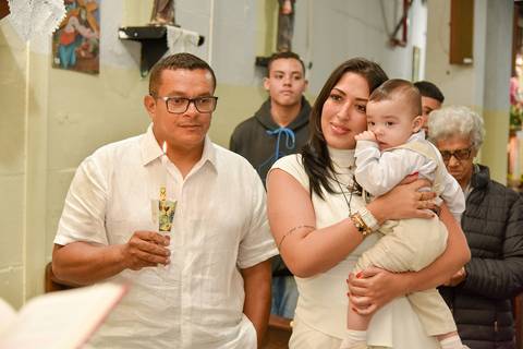 Fotografia Do Bernardo No Colo Da Madrinha E O Padrinho Ao Lado Segurando A Vela Na Paróquia São Judas Tadeu em São Paulo, SP Feita por Priscila Felix Fotógrafa de Casamentos, Ensaios e Família'