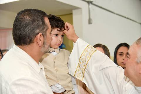 Fotografia Do Padre Passando O Óleo Na Testa Do Theo Na Paróquia São Judas Tadeu em São Paulo, SP Feita por Priscila Felix Fotógrafa de Casamentos, Ensaios e Família'