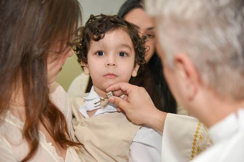 Fotografia Do Padre Passando O Óleo No Peito Do Theo Na Paróquia São Judas Tadeu em São Paulo, SP Feita por Priscila Felix Fotógrafa de Casamentos, Ensaios e Família'
