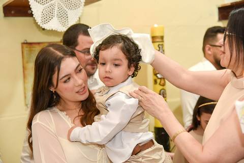 Fotografia Do Theo No Colo Da Madrinha E A Tia Enxugando Sua Cabeça Após o Batismo Na Paróquia São Judas Tadeu em São Paulo, SP Feita por Priscila Felix Fotógrafa de Casamentos, Ensaios e Família'