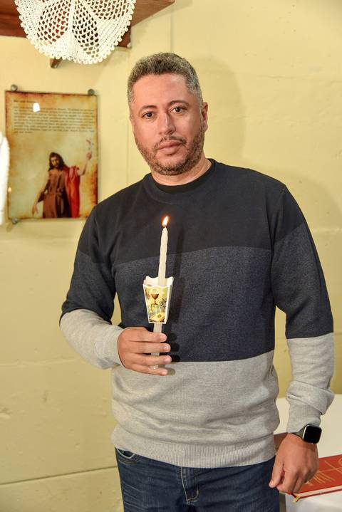 Fotografia Do Padrinho Da Millena Segurando A Vela Acesa Na Paróquia São Judas Tadeu em São Paulo, SP Feita por Priscila Felix Fotógrafa de Casamentos, Ensaios e Família'