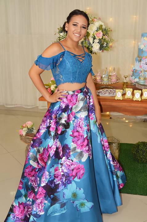 Fotografia da Debutante Em Frente à Mesa do Bolo Com Top Azul e Saia Longa Florida em Itaquera SP Feita por Priscila Felix Fotógrafa de Casamentos, Ensaios e Família'