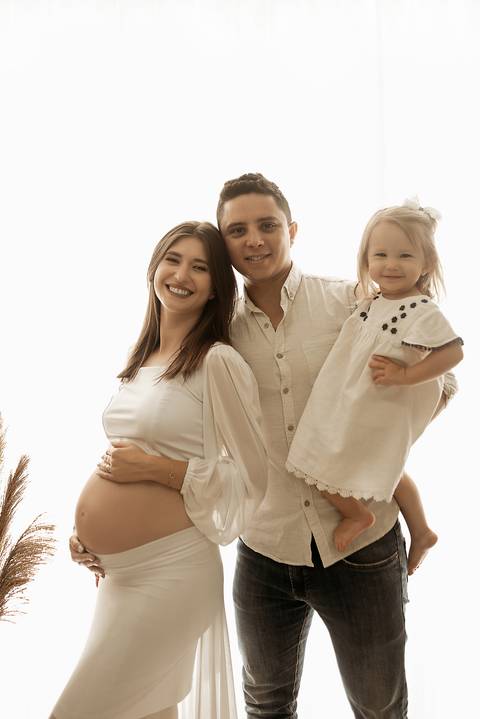Ensaio de gestante em estúdio fotográfico com família.

'