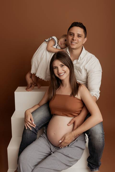 Ensaio de gestante em estúdio fotográfico com família.

'