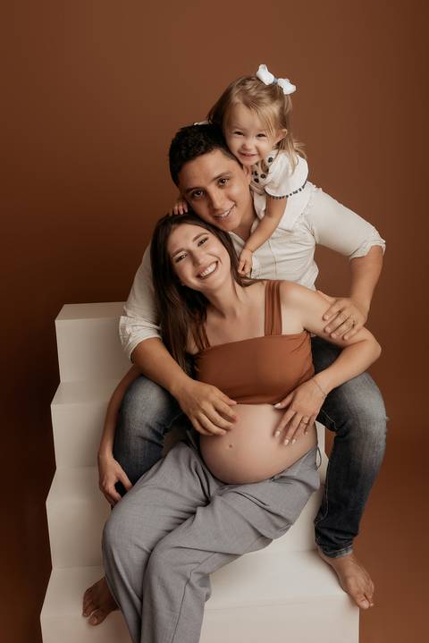Ensaio de gestante em estúdio fotográfico com família.

'