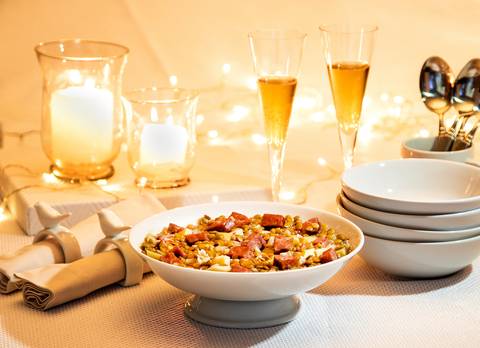 mesa de ano novo com prato de lentilha e champanhe'