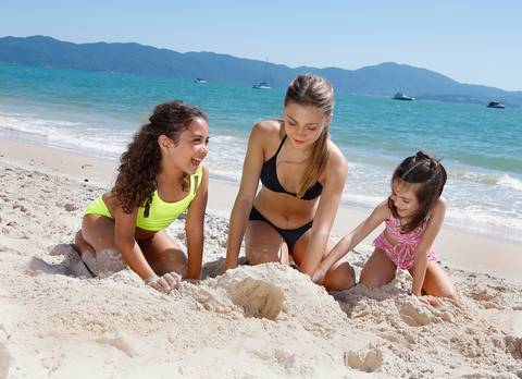 Meninas de biquíni brincando na areia'