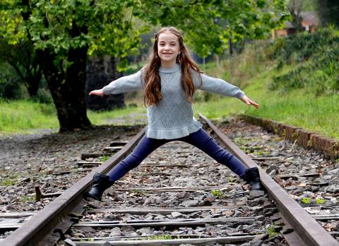 Menina com blusão nos trilhos do trem'