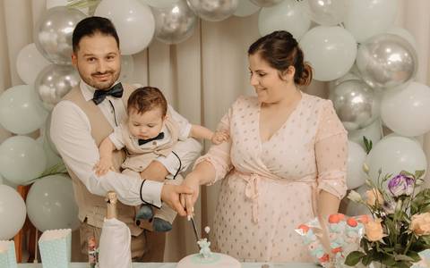 Foto pais e bebé a partir bolo de batizado'