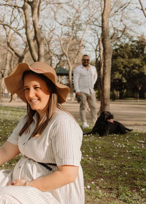 Foto de gravidez em casal no parque com cão'