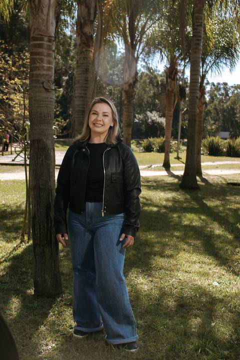 Patrícia-parque-getúlio-vargas-canoas-ensaio-externo-feminino-aniversário-loira-casaco-preto-calça-jeans-azul-jardim'