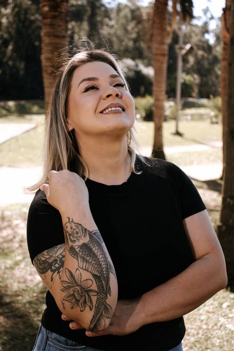 Patrícia-parque-getúlio-vargas-canoas-ensaio-externo-feminino-aniversário-loira-casaco-preto-calça-jeans-azul-jardim-vela-faiscas-casaco-marrom-óculos'