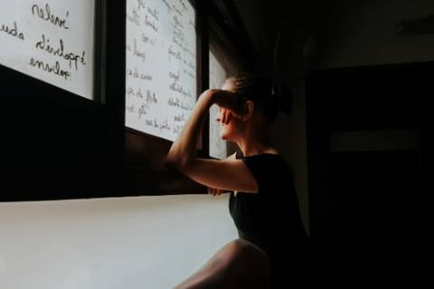 mujer mira a traves de la ventana'