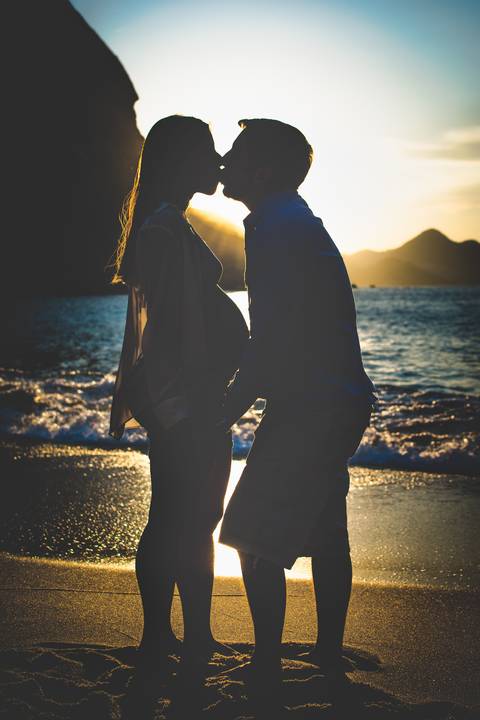 Fotografia de gestante, ensaio na praia vermelha durante as primeiras horas do dia! silhueta na golden Hour'
