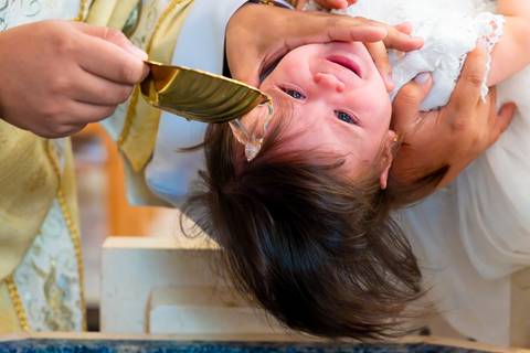 Momento do batismo com água benta na Igreja Nossa Senhora de Lourdes, fotógrafo de batizado Alphaville'