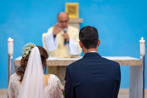 Fotografia de casamento no campo em Itu. foto casamento no campo benção do padre nos noivos ajoelhados no altar'