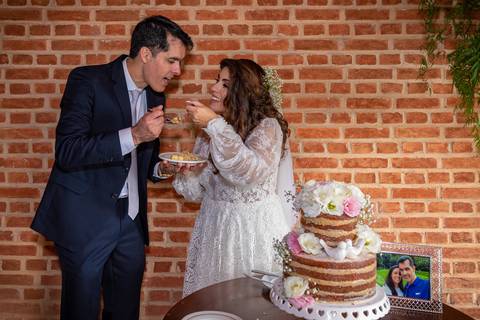 Fotografia de casamento no campo em Itu. foto casamento no campo noivos comendo o bolo do csamento'