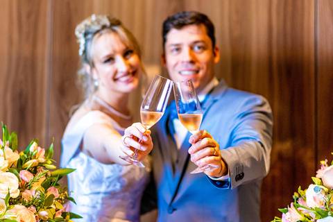foto dos noivos brindando com champanhe na mesa do bolo do casamento, foto casamento alphaville, foto casamento barueri'