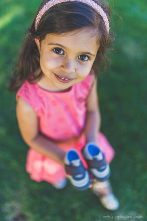 menina segurando sapatinhos de bebê'