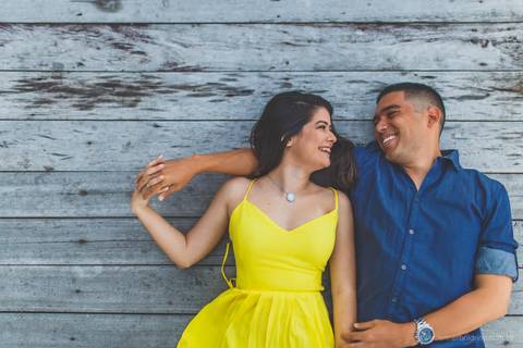 noivos deitados num deque de madeira'