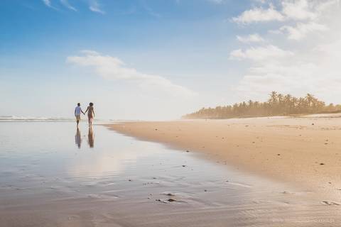 casal gestante caminhando na praia'