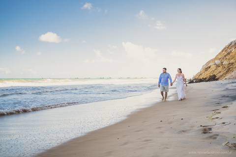 noivos caminhando na praia'
