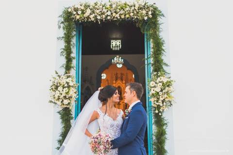 retrato dos noivos na frente da igreja'