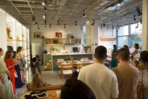 Visão da plateia de convidados e influenciadores no workshop de chá, com a professora ao fundo, demonstrando o engajamento do público no evento Westwing em Moema, São Paulo.'