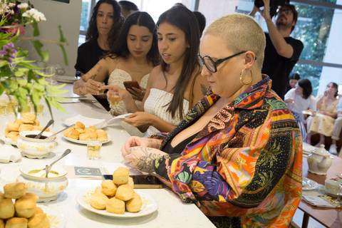 Influenciadores servindo-se do chá em xícaras elegantes, desfrutando da experiência do workshop no evento Westwing + Netflix Bridgerton em Moema, São Paulo.'