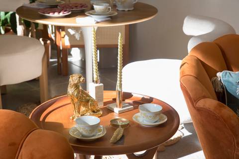 Mesa de canto decorada com requinte, apresentando xícaras de chá de porcelana e outros objetos que evocam a atmosfera de Bridgerton, no evento Westwing em Moema, São Paulo.'