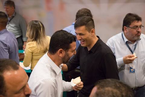 Funcionários do GPA rindo e conversando animadamente durante o coffee break do evento Start de Ano 2024, aproveitando o momento de descontração e networking na sede em São Paulo.'