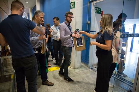 Momento da entrega de brindes aos participantes no final do evento Start de Ano GPA 2024, com funcionários recebendo os itens na sede em São Paulo.'