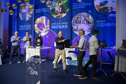 Diretor do GPA recebendo uma homenagem no palco durante o Evento de Fim de Ano 2024 na sede em São Paulo, em um momento de reconhecimento e gratidão.'