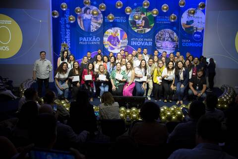 Foto posada de funcionários premiados no palco do Evento de Fim de Ano GPA 2024, celebrando suas conquistas e o reconhecimento na sede em São Paulo.'