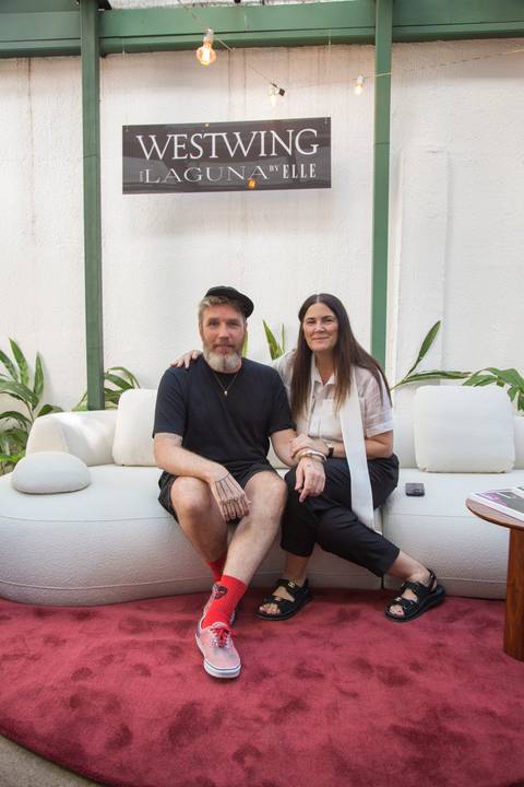 Duas participantes do evento Westwing + ELLE no Restaurante Chou em São Paulo, posando juntas para uma foto no sofá modular, com sorrisos e elegância.'