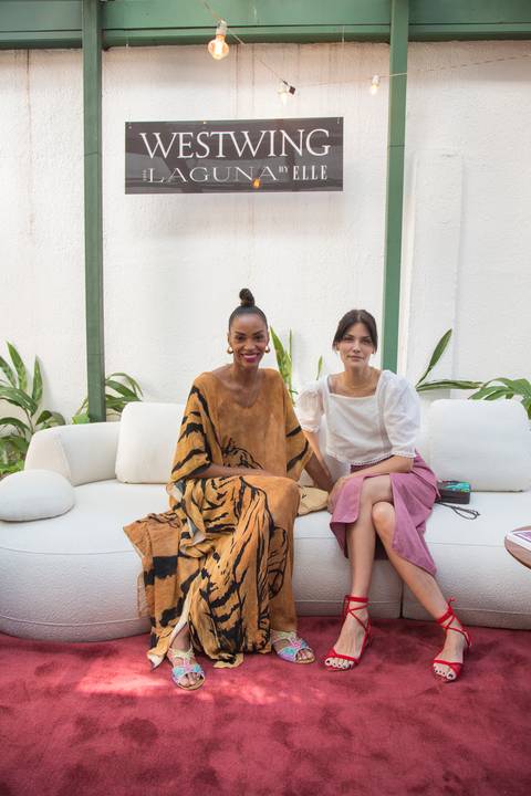 Duas modelos posando para uma sessão de fotos no sofá modular da Westwing, parte do cenário do evento com a ELLE no Restaurante Chou em São Paulo, destacando o design das peças.'