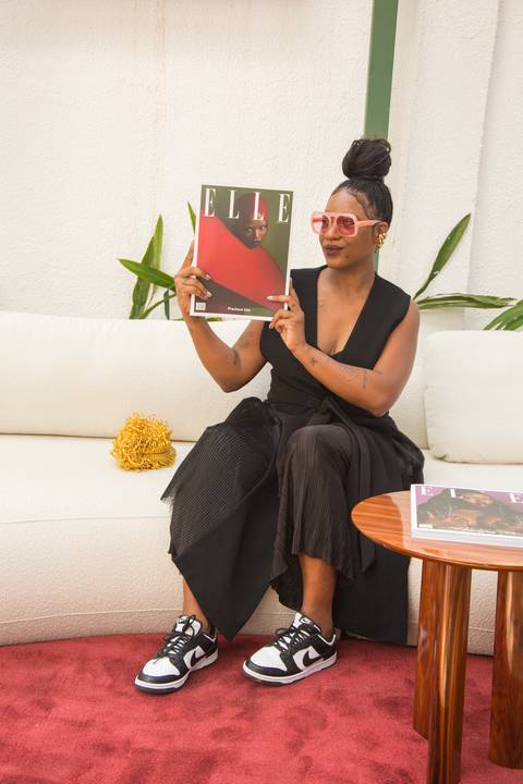 Modelo de capa da revista ELLE segurando a edição da qual foi capa, posando no evento Westwing + ELLE no Restaurante Chou em São Paulo, celebrando sua participação.'