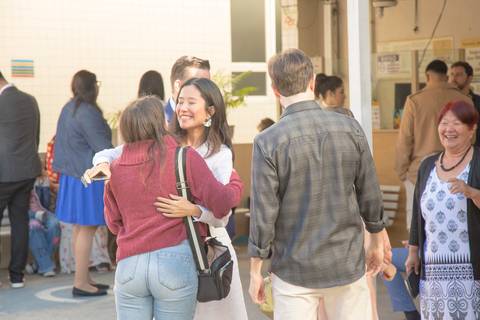 Casal de noivos recebendo e cumprimentando seus parentes com sorrisos, na entrada do 13º Cartório do Butantã, em São Paulo, antes da cerimônia de casamento.'